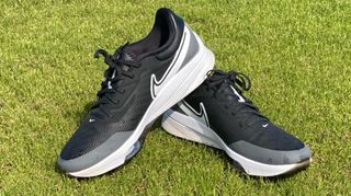 Nike Air Zoom Infinity Tour NEXT% Shoes resting on the golf course