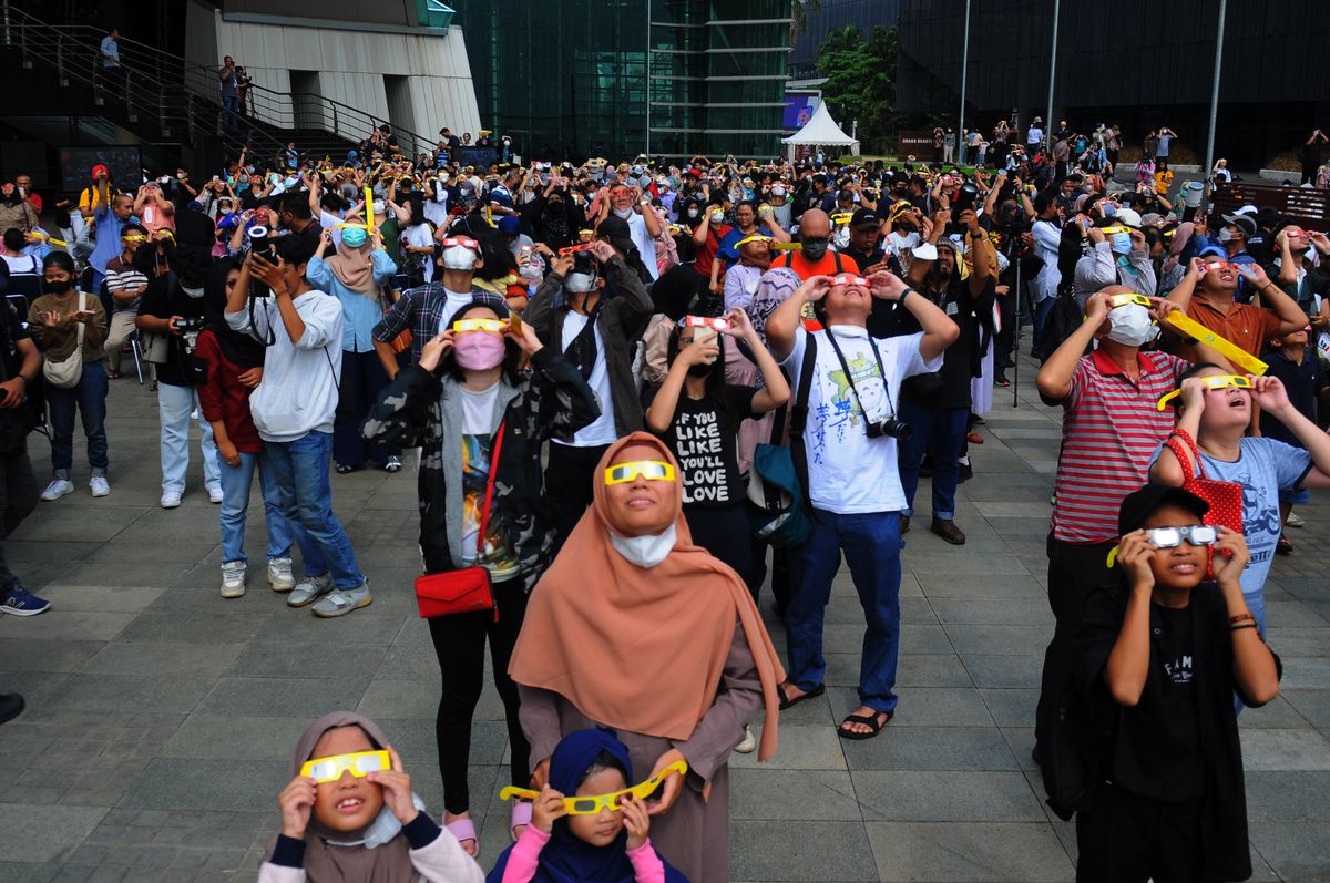 People wear protective glasses to watch a partial hybrid solar eclipse at Ismail Marzuki Park in Jakarta, Indonesia on April 20, 2023.