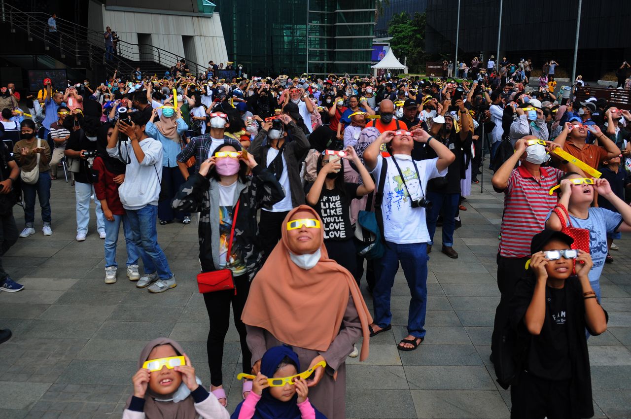 People wear protective glasses to watch a partial hybrid solar eclipse at Ismail Marzuki Park in Jakarta, Indonesia on April 20, 2023.