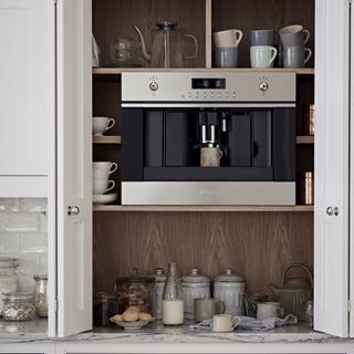 Built-in coffee machine with coffee station set up in a wall cabinet
