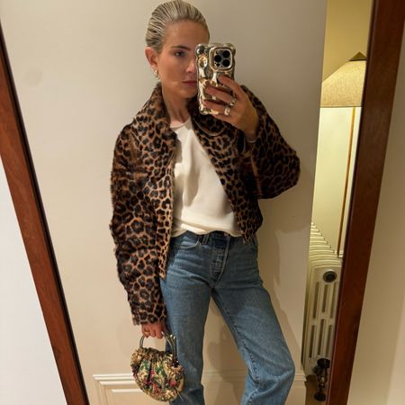 Lucy Williams wearing a leopard jacket, white t-shirt and blue jeans.