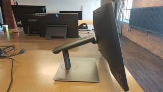 This Dell display is attached to a flexible arm atop an upright stand.