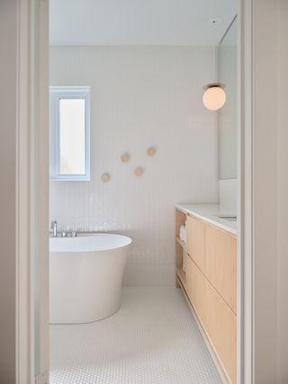 An all white bathroom with wooden elements