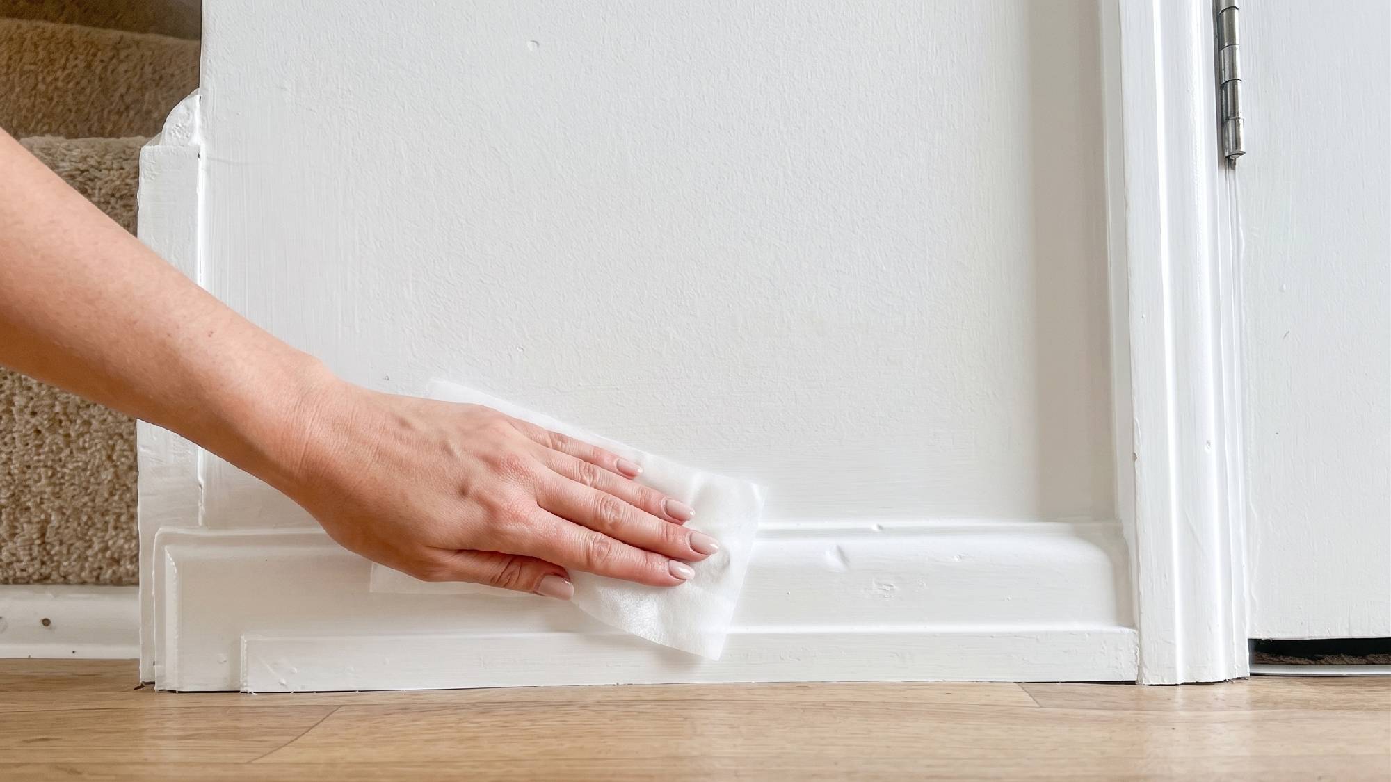 Wiping baseboards with dryer sheet