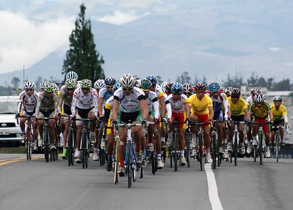 Byron Guama (right, in yellow) watches the front of the peloton.