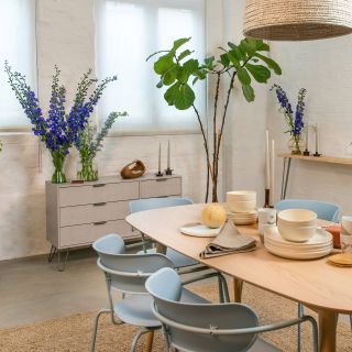 dinning room with white brick wall dinning table and chair flower vases on sideboard