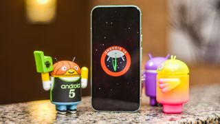 Google Pixel 8a showing Android 14 screen with Android figurines beside