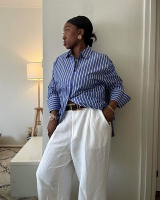 Woman in blue striped shirt and white linen pants.