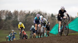 Cyclocross racers battling up a muddy climb