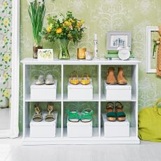 white shoe rail with flower vase and storage items in green wallpaper room