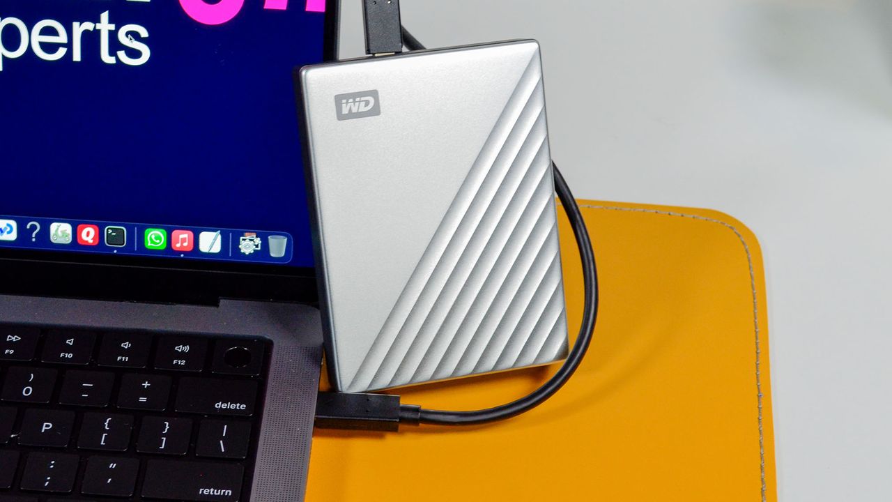A WD My Passport Ultra for Mac on a desk connected to a MacBook
