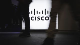 Pedestrians walking in front of Cisco logo with motion blur