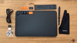 A black Veikk Voila L Pen Tablet sitting on a wooden desk
