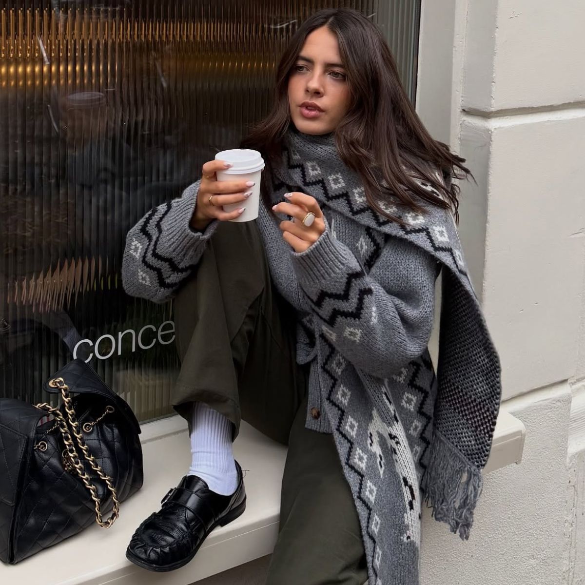 Woman wears grey cardigan, khaki trousers