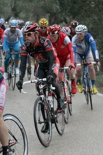 A wet peloton approaches the ascent of the category two Coll de Soller.