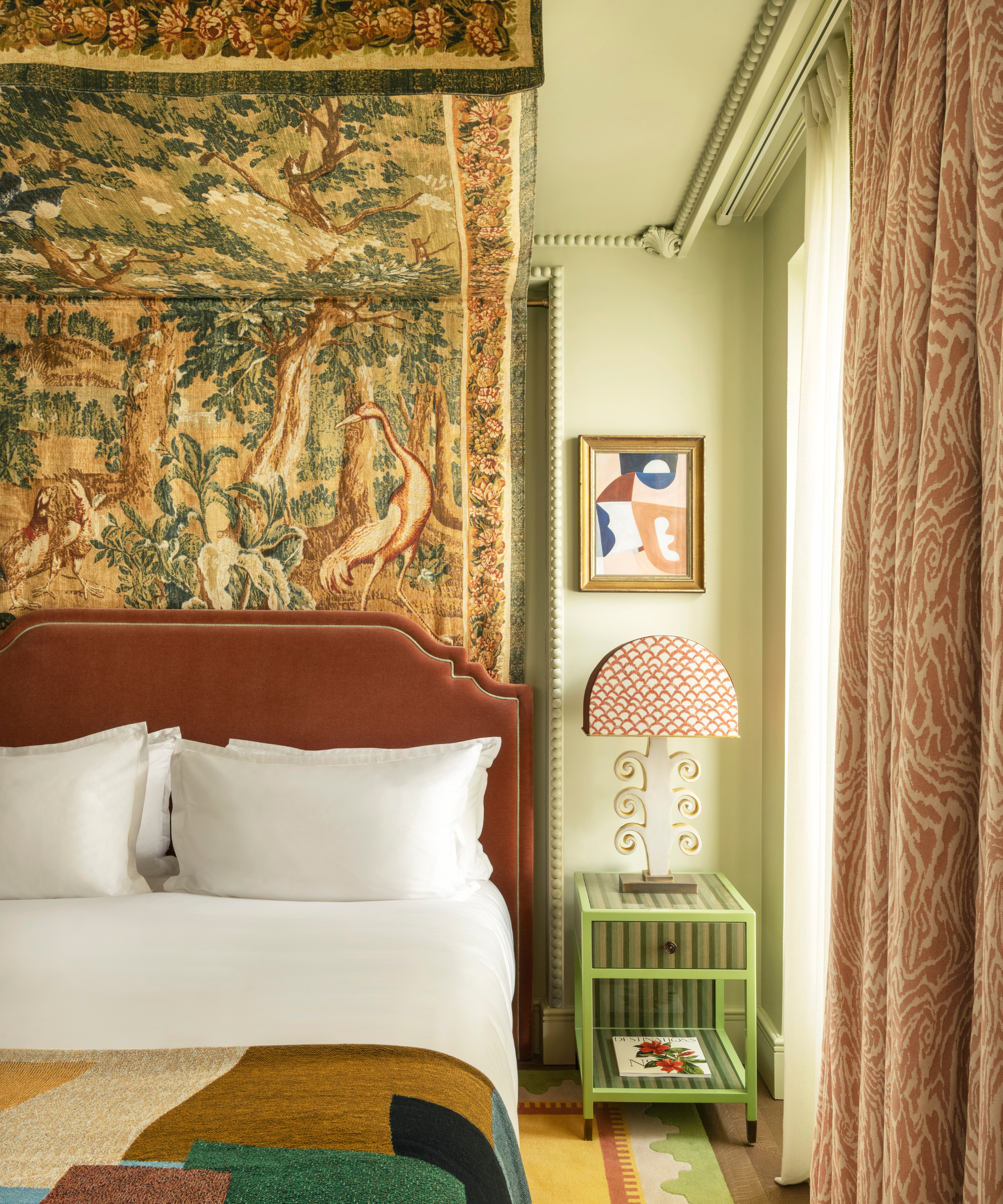 A green bedroom with a fabric four poster
