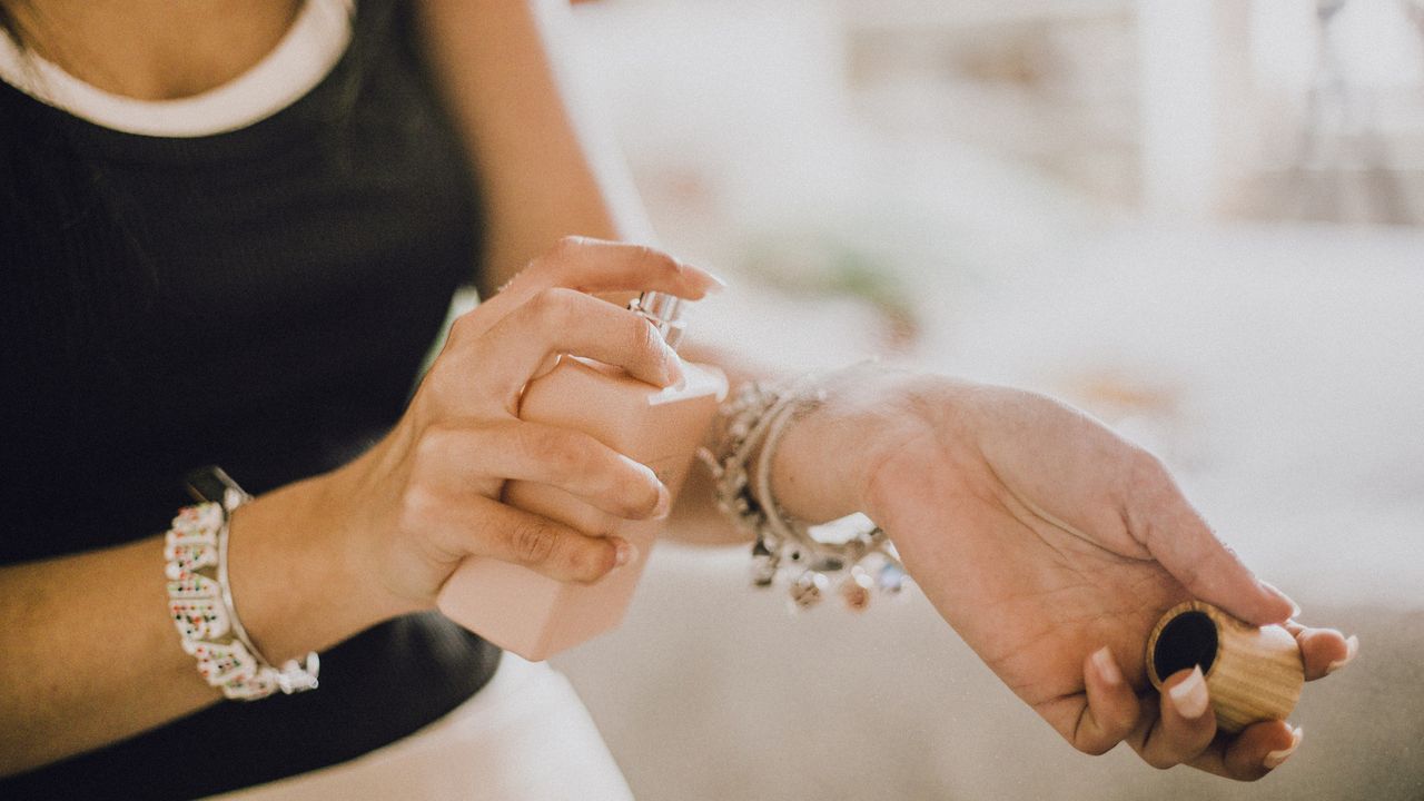 Woman spraying perfume onto her wrists