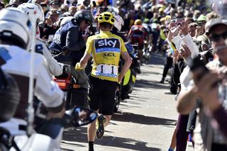 Chris Froome runs towards Chalet Reynard after an incident with a television motorbike on Stage 12 of the 2016 Tour de France