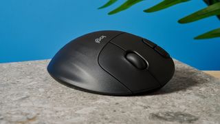 A black Logitech Ergo M575 ergonomic mouse with a teal trackball on the left side