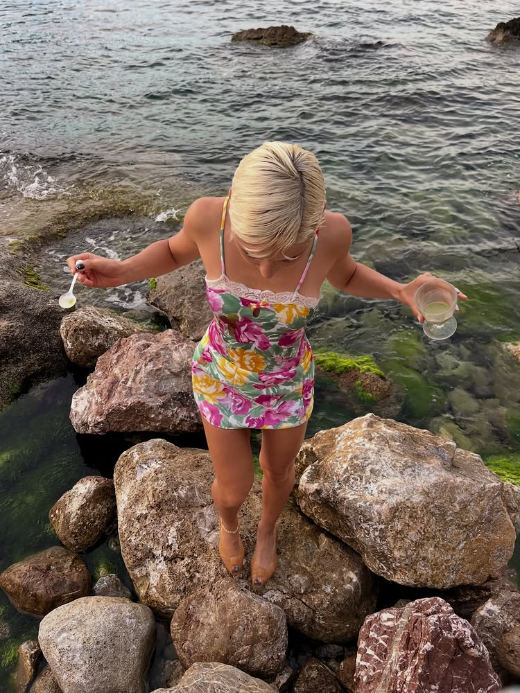 An image of @irisaw wearing gold sandals with a floral mini dress.