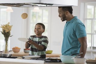 Father and son flipping pancakes