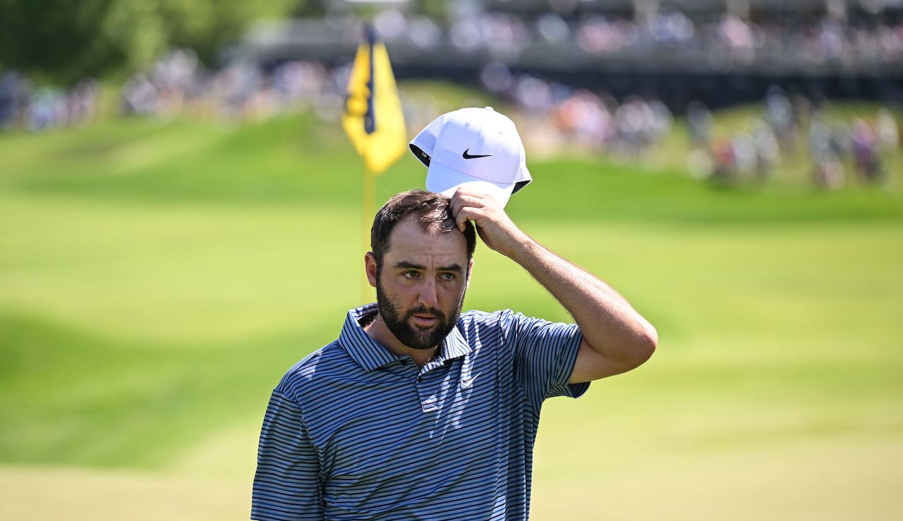 Scottie Scheffler takes his hat off as he walks off the green