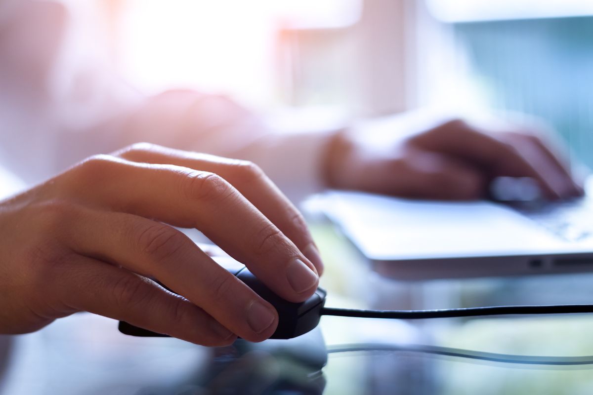 person using a mouse with a keyboard