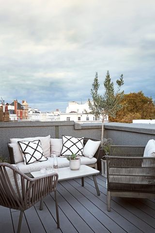 roof top garden with outdoor sofa and grey rattan chairs