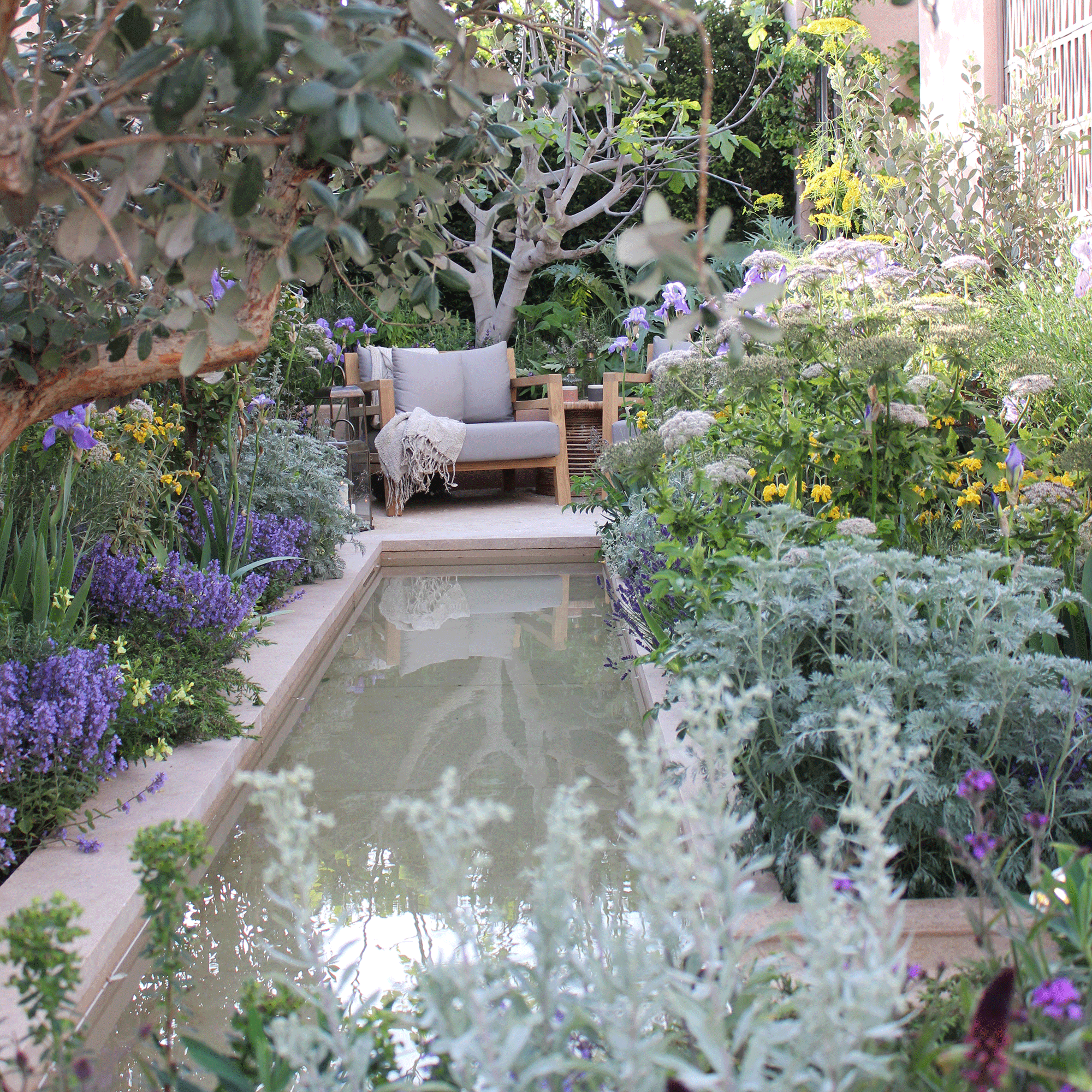 Small garden with long water feature and chair