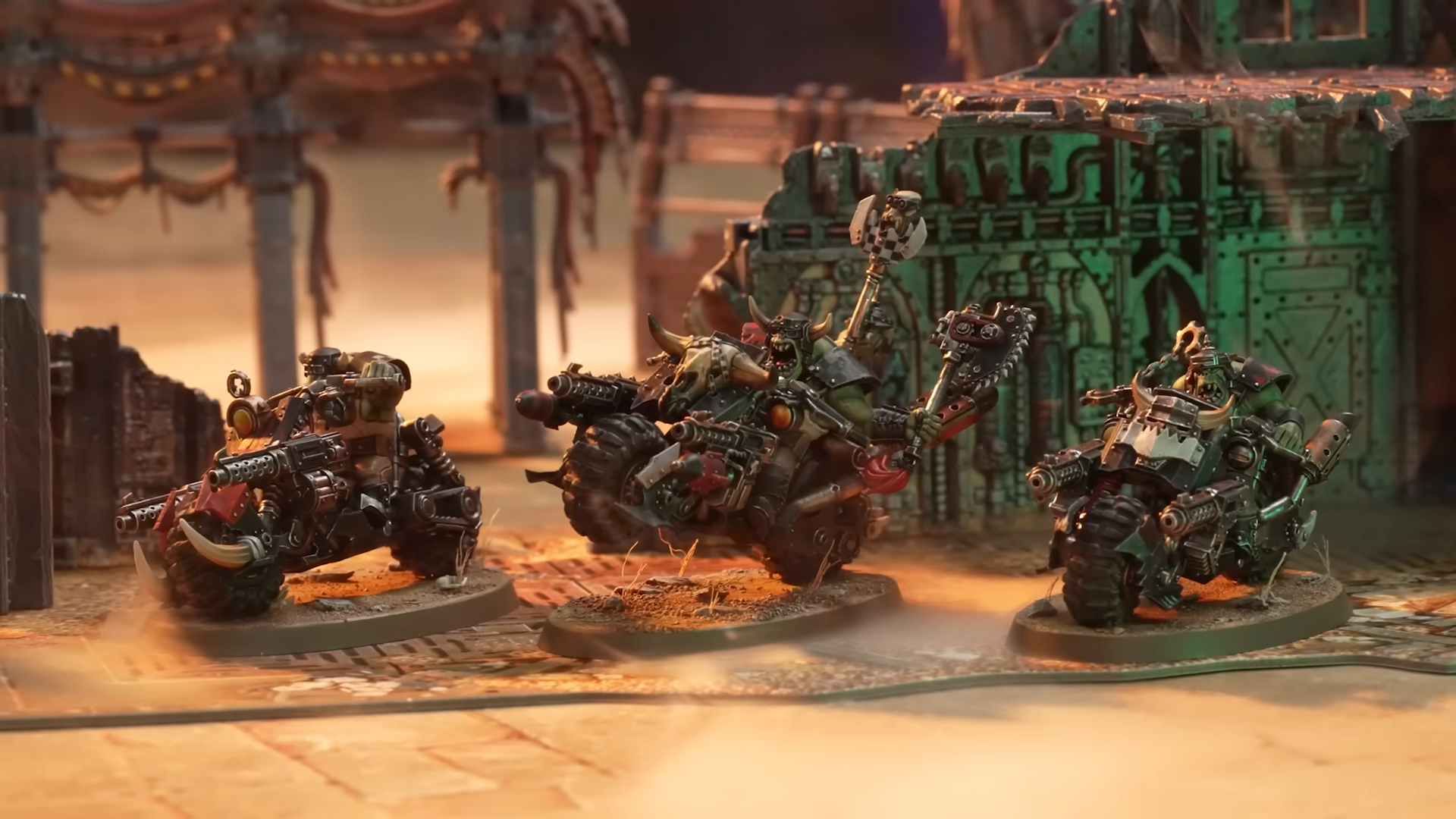 A trio of Ork bikes against a dusty battlefield full of ruined terrain