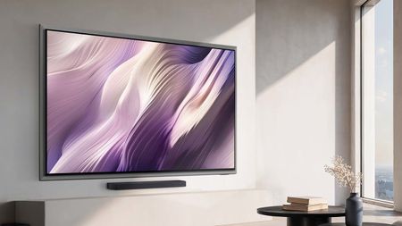 A wall-mounted Samsung S95H OLED TV displaying abstract, purple-colored imagery in a modern living room illuminated by sunlight