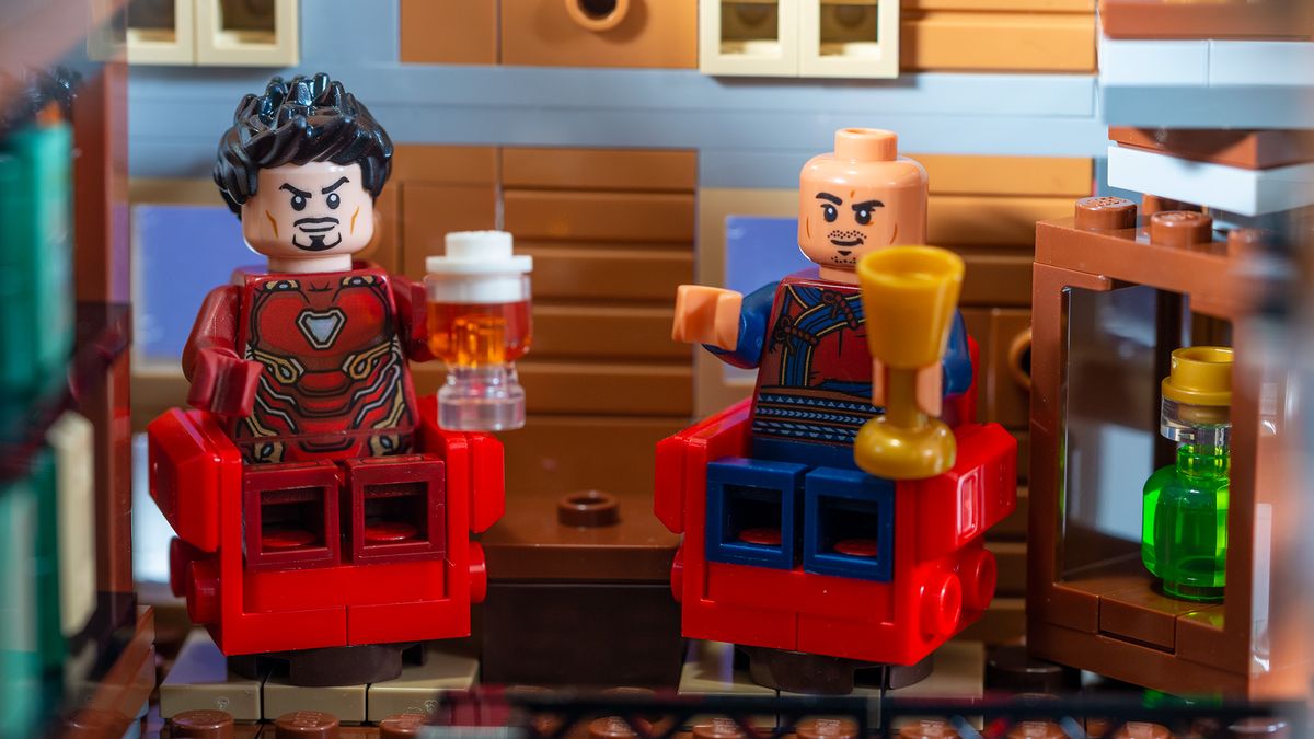 Iron Man and Wong sitting in red chairs on the second floor.