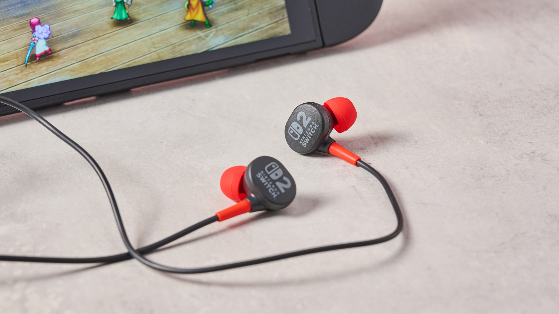 PowerA Wired Earbuds for Nintendo Switch 2 beside Switch 2 console with Dragon Quest I &amp;amp; II HD-2D Remake on display