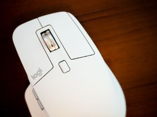 A white Logitech MX Master 3S for Mac mouse on a brown wooden desk