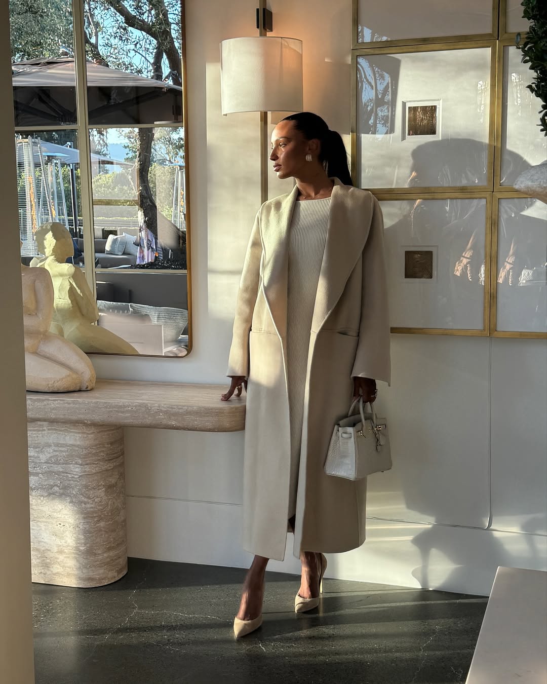 @jastookes wears a cream coat with a matching Hermes Birkin bag