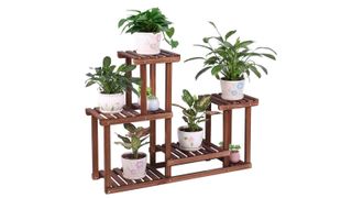 A wooden plant stand with multiple pots on different levels