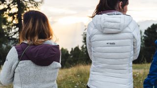 The back of two hikers wearing Columbia jackets