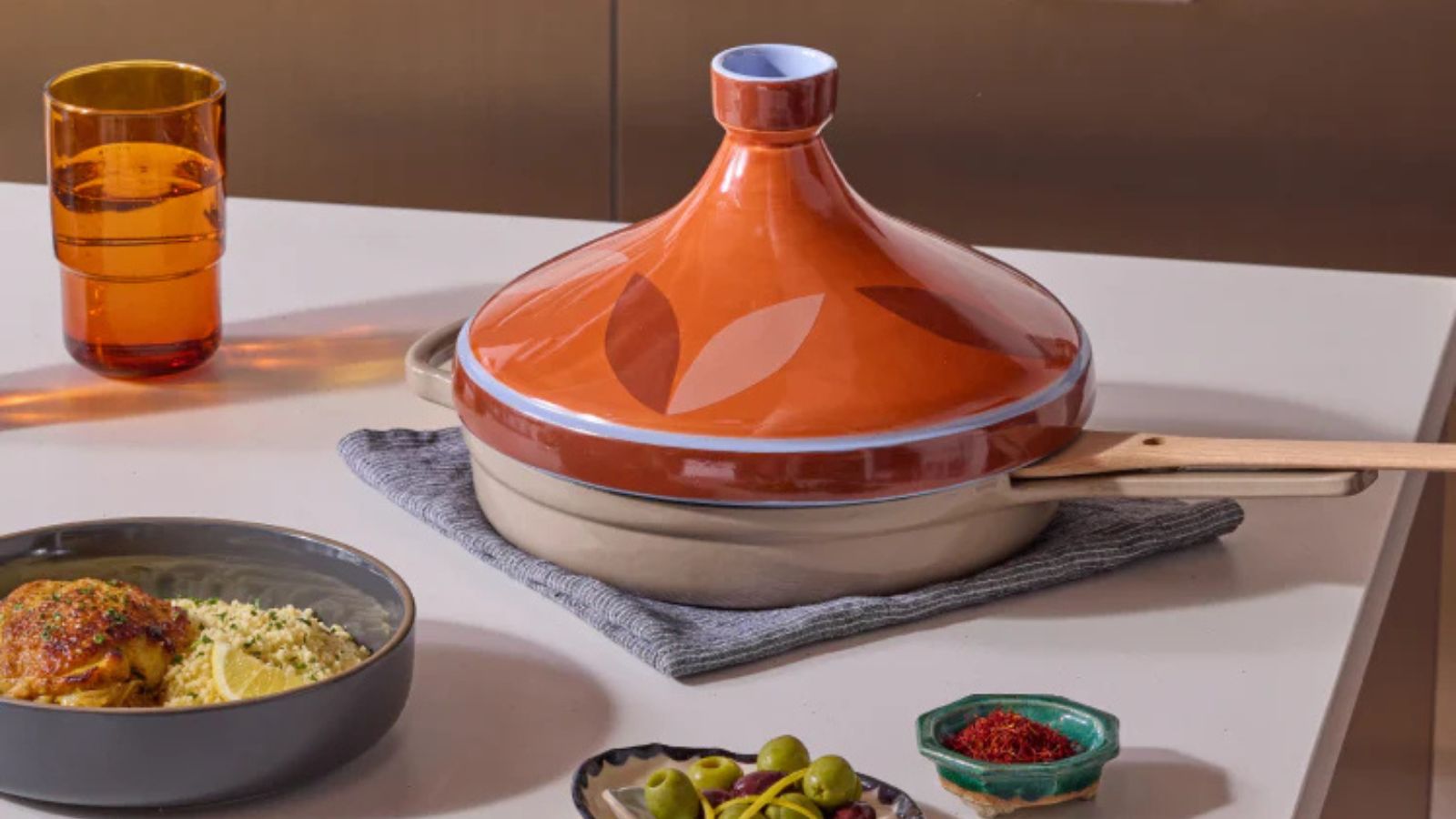 Our Place Tagine Lid on a kitchen island next to a dish of tagine with cous cous
