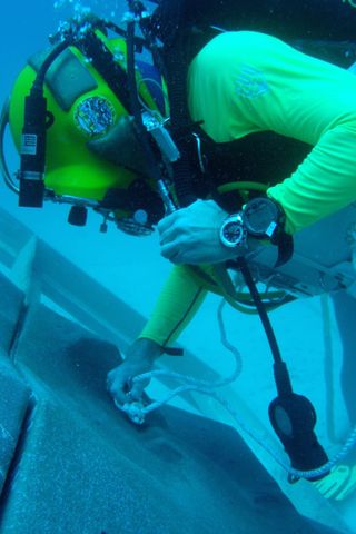 NEEMO diver anchoring on a simulated asteroid surface.