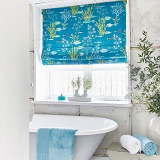 Blue blind with under the sea pattern in white bathroom