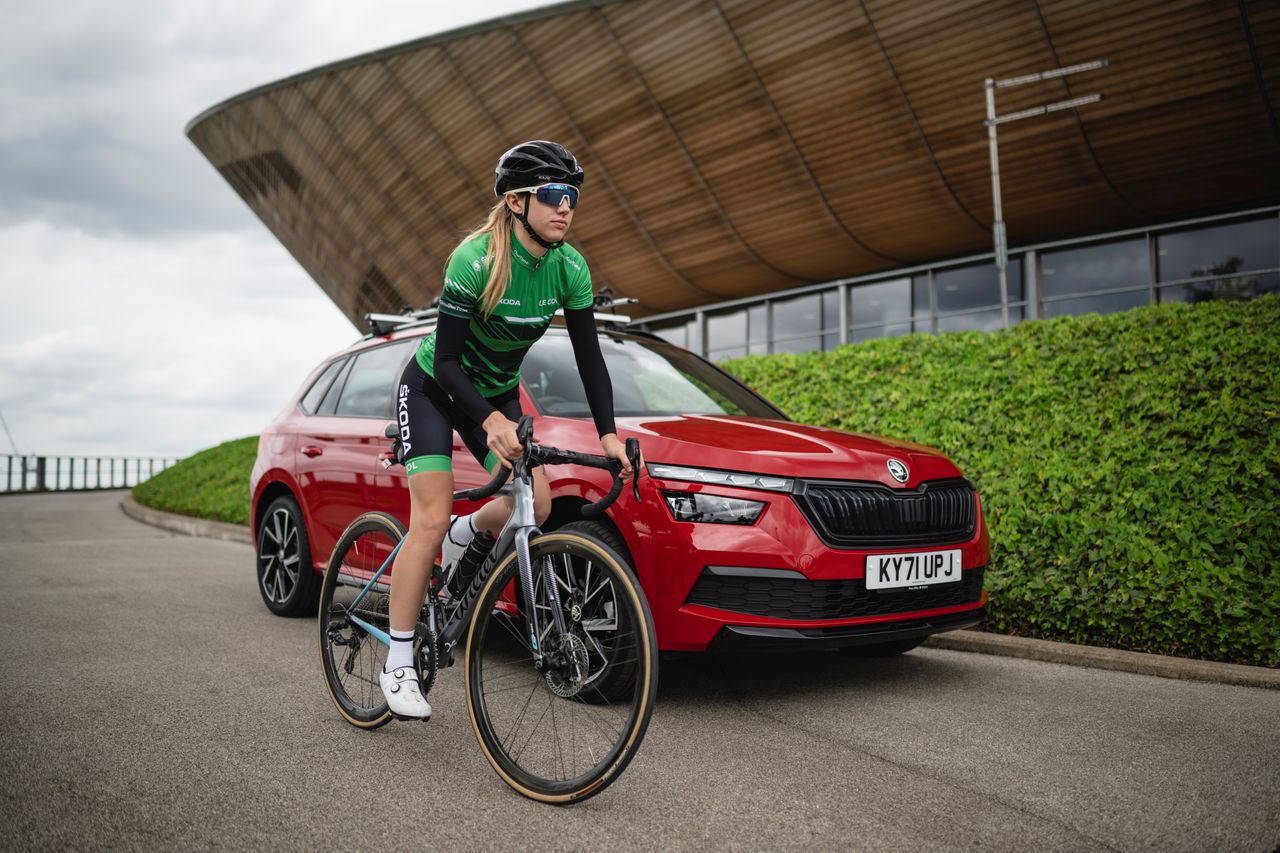 Cyclist Kiera McVitty rides past a Skoda Kamiq