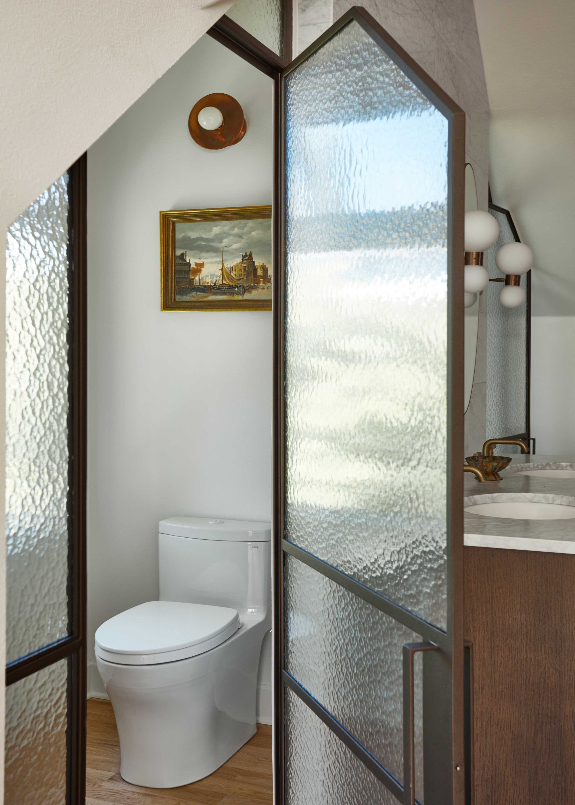 a bathroom with frosted glass around WC