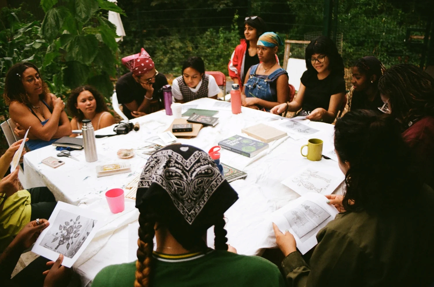 People eating, chatting, cooking in a community garden.