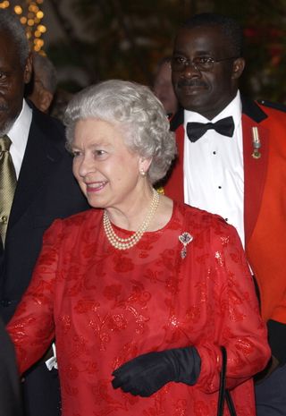 Queen Elizabeth IIattending A Reception At King's House, The Home Of The Governor General Of Jamaica, Where She Is Staying During Her Visit. Red Silk Embossed Chiffon Dress Designed By Karl Ludwig