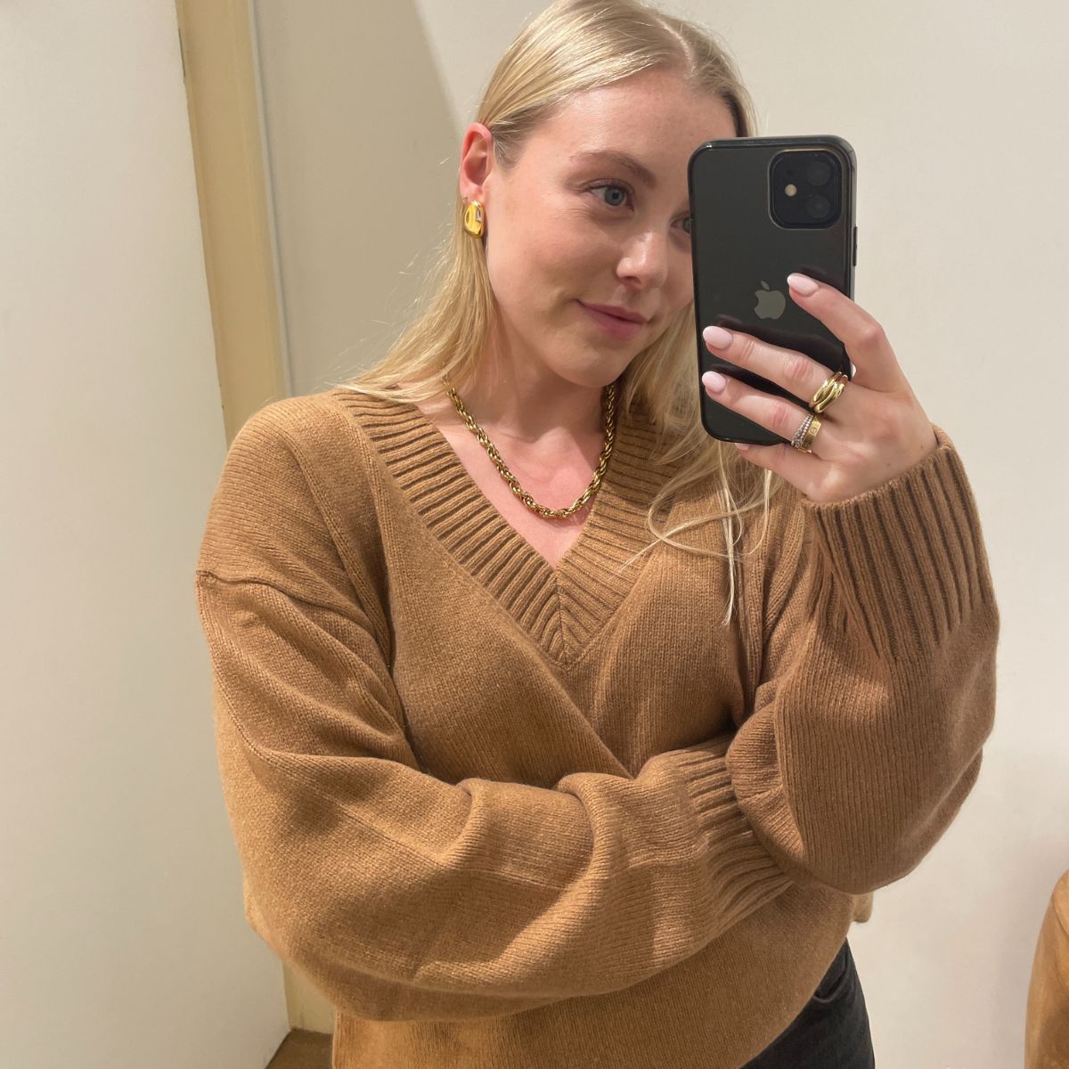 Woman wears camel v-neck jumper