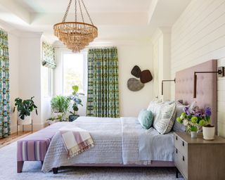 neutral bedroom with green curtains and purple bed
