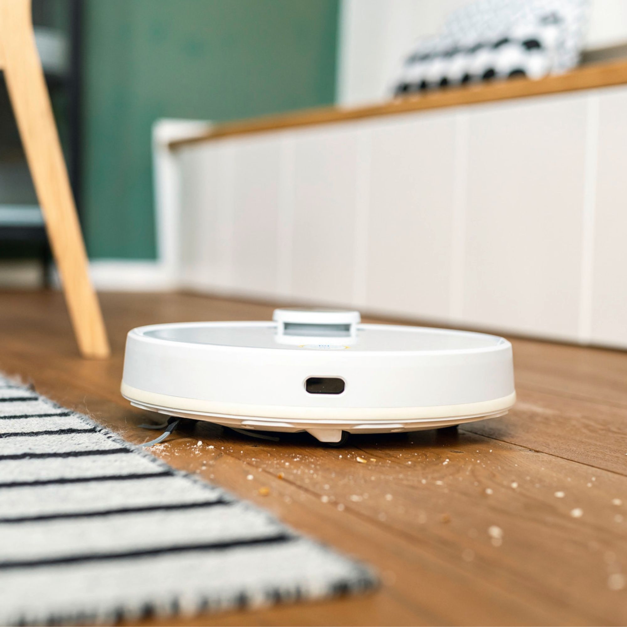 Ka&amp;#776;rcher RCV 3 Robot Vacuum Cleaner cleaning crumbs off a wooden floor