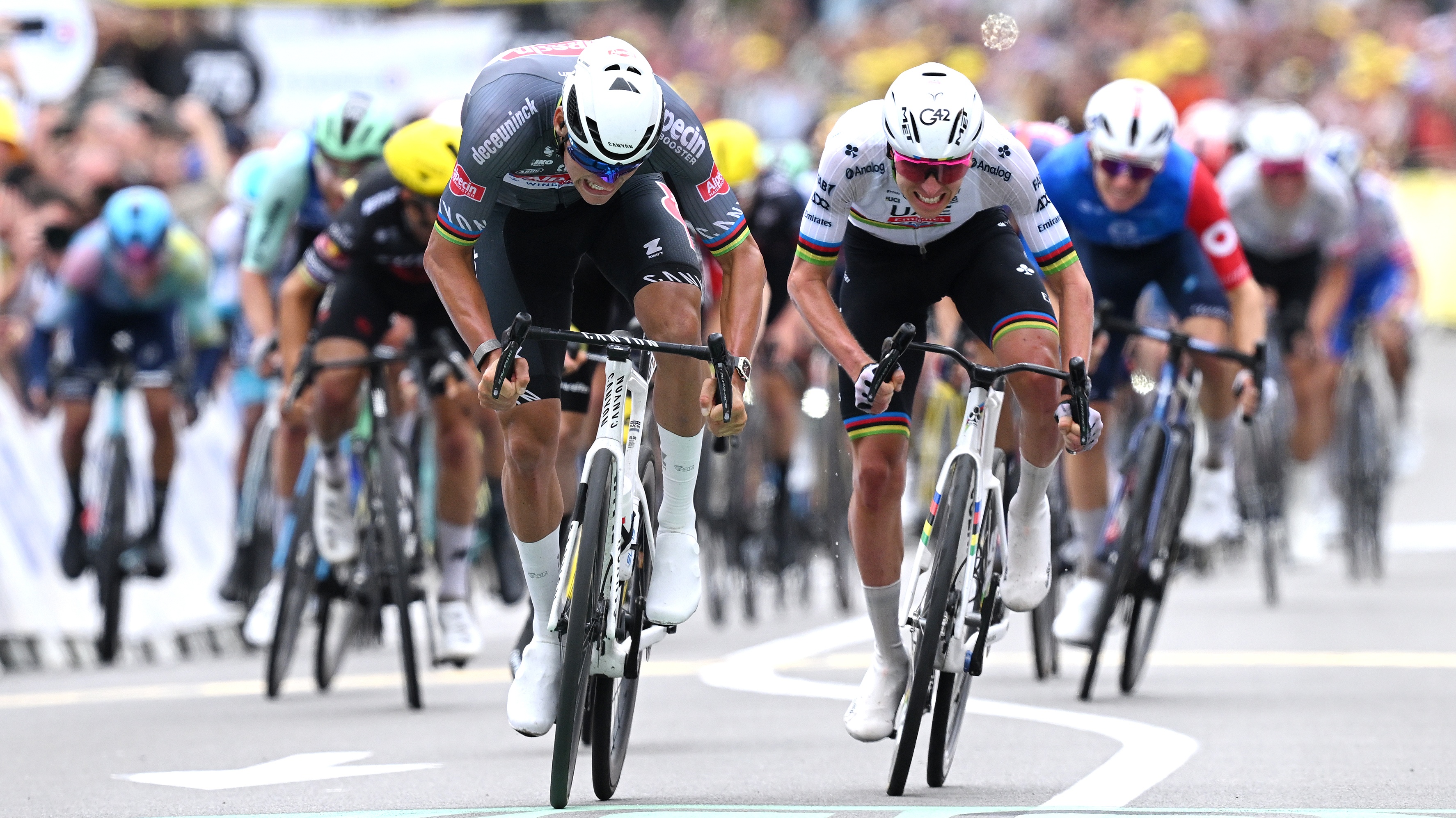 Tour de France Stage 2 race as Mathieu van der Poel and Tadej Pogacar sprint for the line.