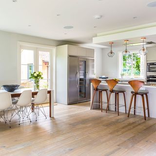 kitchen and dining area with white wall and table and chairs