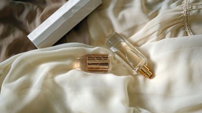 A gold perfume body mist on a cream silk dress